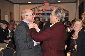 A woman looks on as Dr. Mark Druffner, right, straightens a guest’s tie at the April 11 Mission Possible Gala in Stillwater, Minnesota. This is the sixth year the Druffners have hosted the event to raise money for their mission work in Tanzania. This year’s theme was Downton Abbey. (Submitted photo)